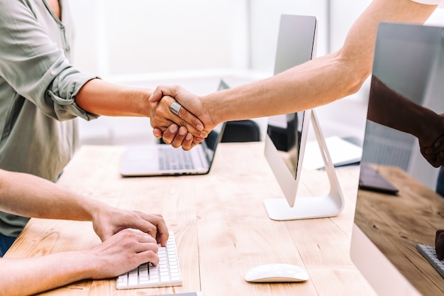 Close up. business people shaking hands near the desktop. business concept