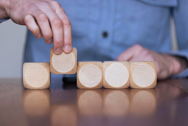 Close up of a business person arranging large wooden blocks Business strategy and solutions