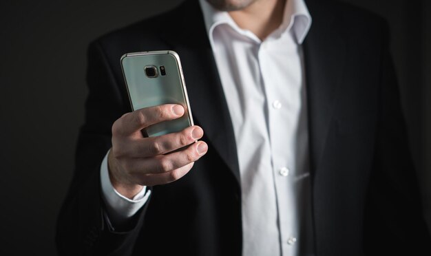 close up of a business person looking at his mobile phone with blurred background
