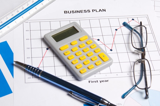 Close up of business plan with graphs charts and calculator on the table