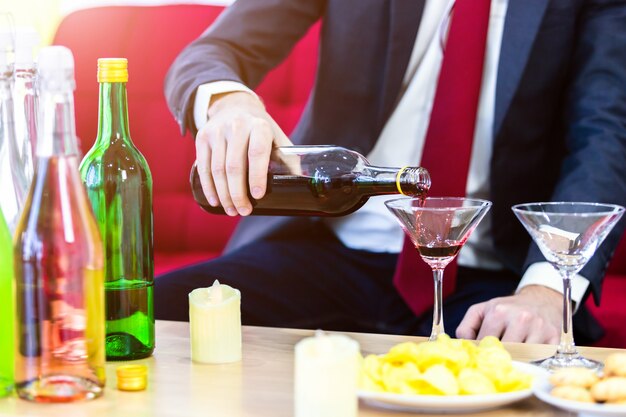 Photo close up of a business suit of man pouring champagne into glass