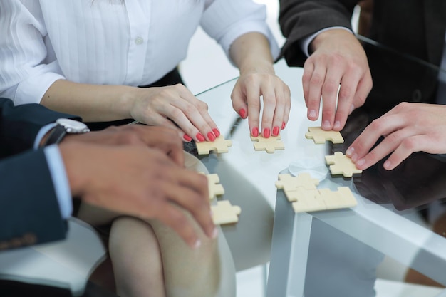 Close up business team assembling puzzle pieces