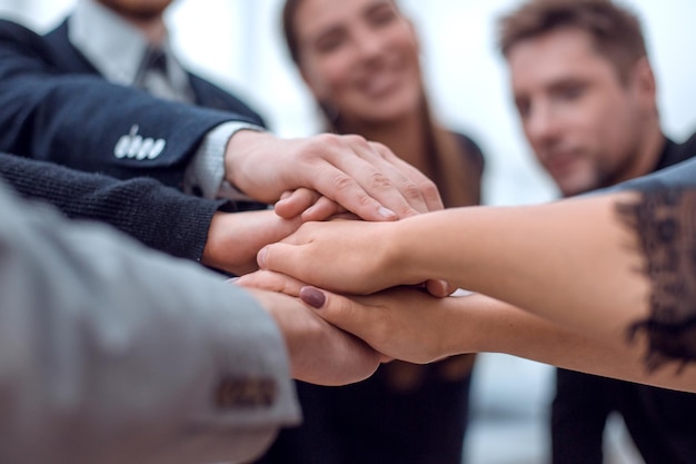 Close up business team putting their hands together