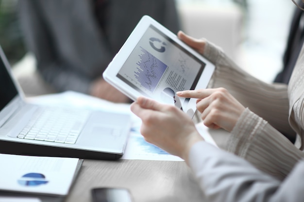 Close up.the business team uses a digital tablet to verify financial data.