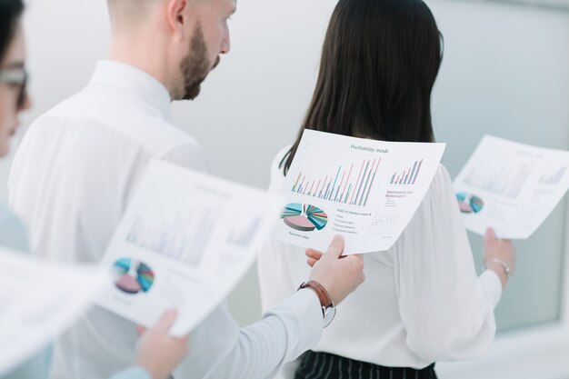 Close up.business team with financial data standing in line. business concept