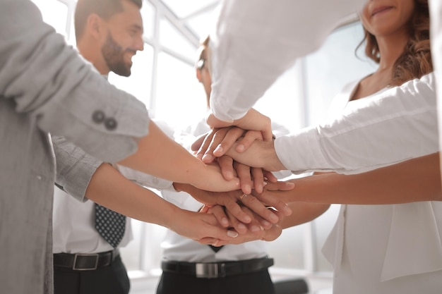 Close up business team with hands folded together