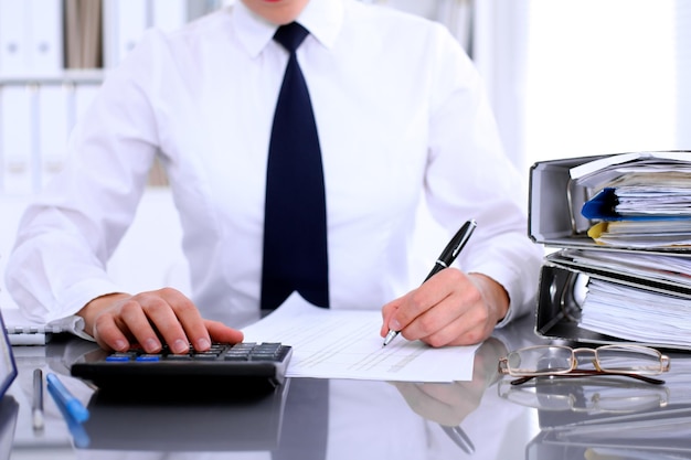 Close up of business woman making report calculating or checking balance