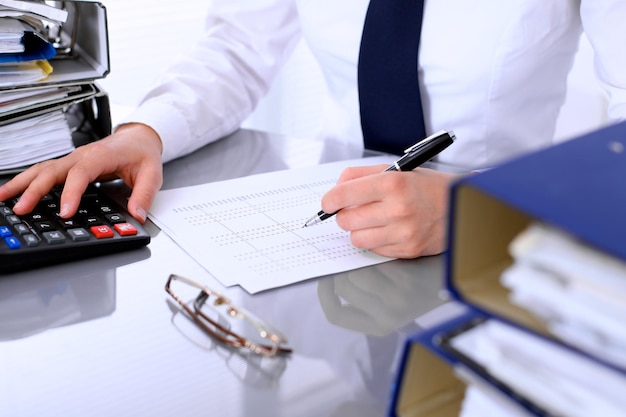 Close up of business woman making report calculating or checking balance