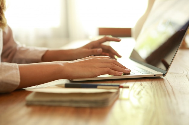 Photo close up business woman typing on laptop on wooden desk