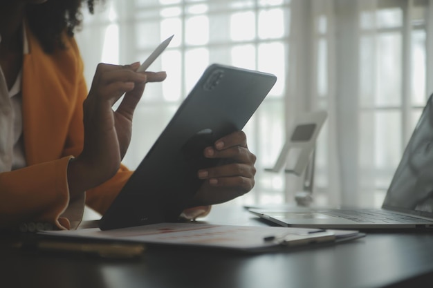 Close up Business woman using calculator and laptop for do math finance on wooden desk tax accounting statistics and analytical research concept