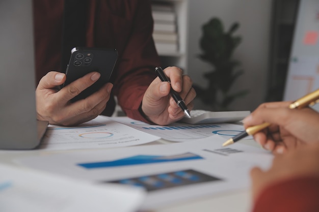 Close up Business woman using calculator and laptop for do math finance on wooden desk tax accounting statistics and analytical research concept