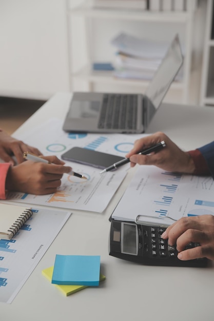 Close up business woman using calculator and laptop for do math finance on wooden desk tax accounting statistics and analytical research concept