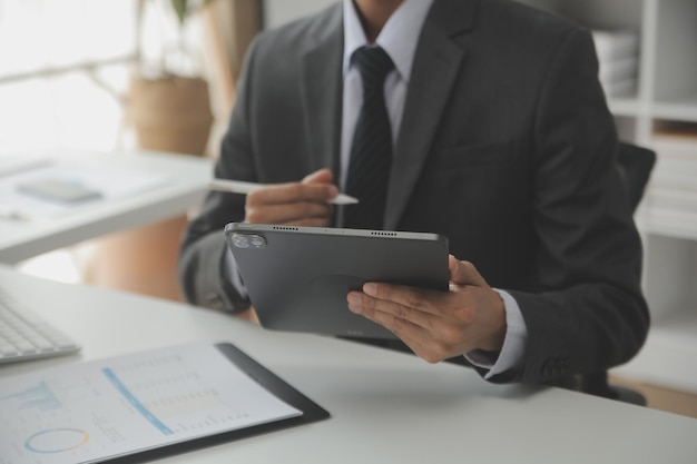 Close up Business woman using calculator and laptop for do math finance on wooden desk tax accounting statistics and analytical research concept