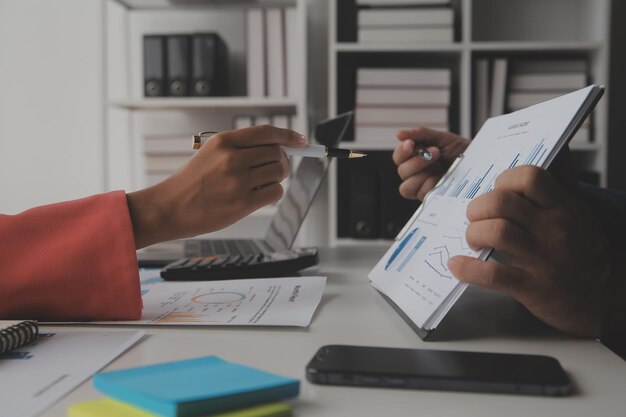 Close up Business woman using calculator and laptop for do math finance on wooden desk tax accounting statistics and analytical research concept