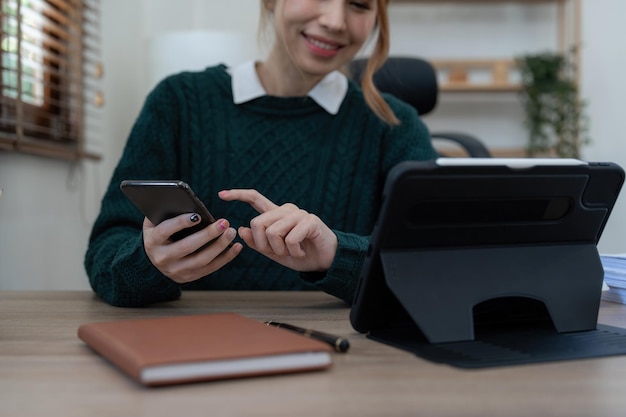 Close up Business woman using calculator and phone for do math finance on wooden desk in office and business working background tax accounting statistics and analytic research concept