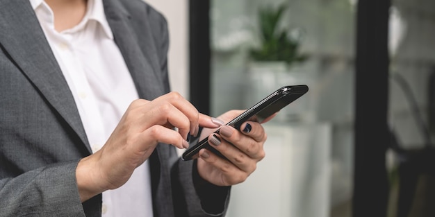 Close up of business woman using mobile smart phone