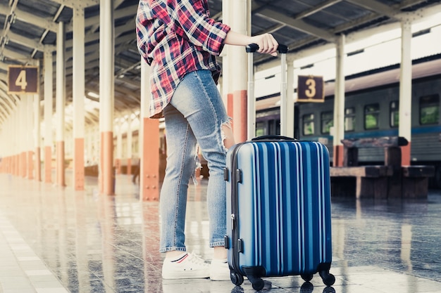 彼女の週末旅行のための鉄道駅でスーツケースとビジネスの女性を閉じます。