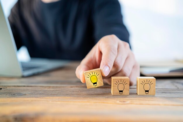 Close up businessman arranging a small wooden block with a light bulb drawing