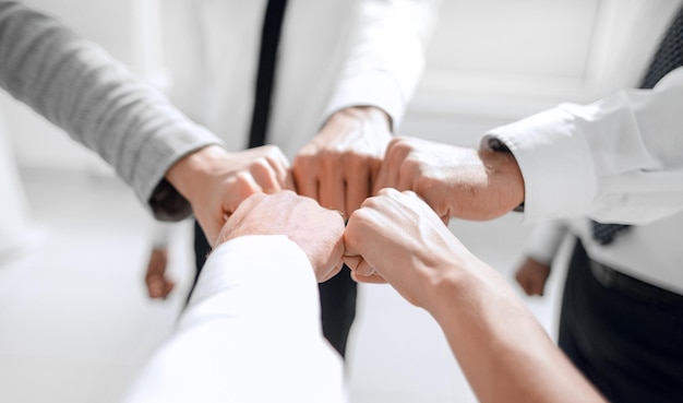 Close up businessman and businesswoman making a fist bump on building background