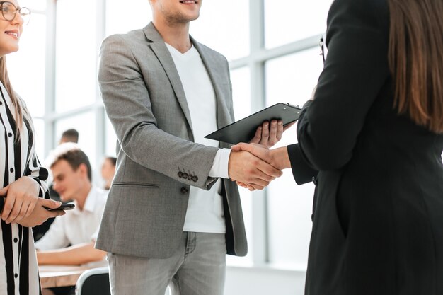 Close up. businessman and businesswoman shaking hands with each other. the concept of cooperation