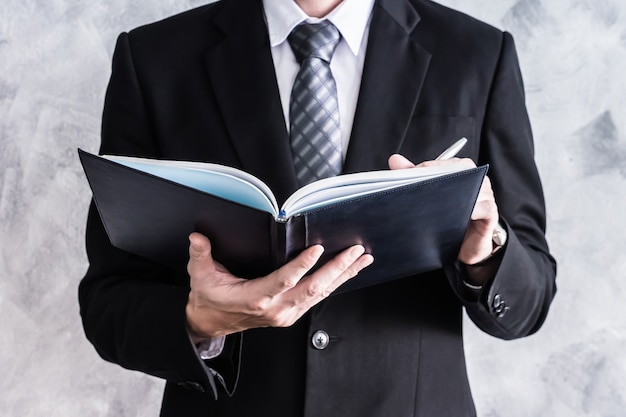 Close up of businessman checking documents on grunge background.