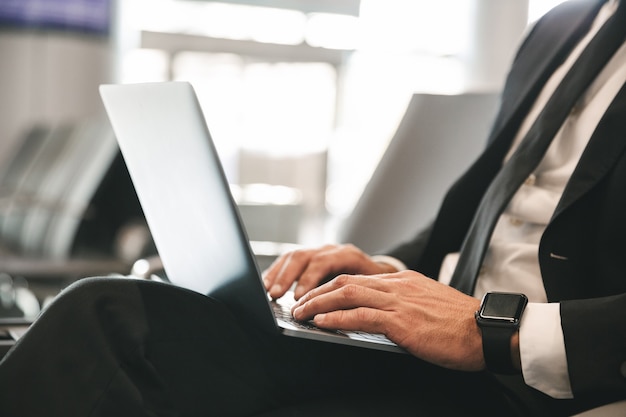 Close up of businessman dressed in suit using laptop