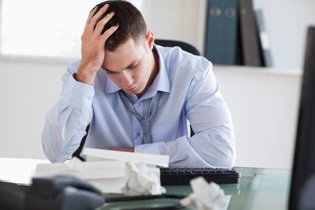 Close up of businessman frustrated with paperwork