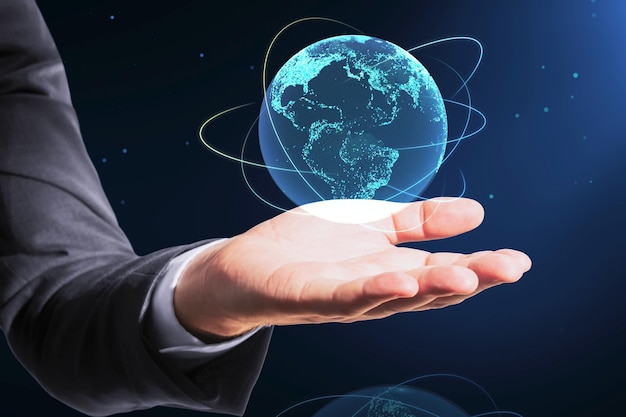 Close up of businessman hand holding creative glowing globe hologram on dark background Technology metaverse and digital map concept