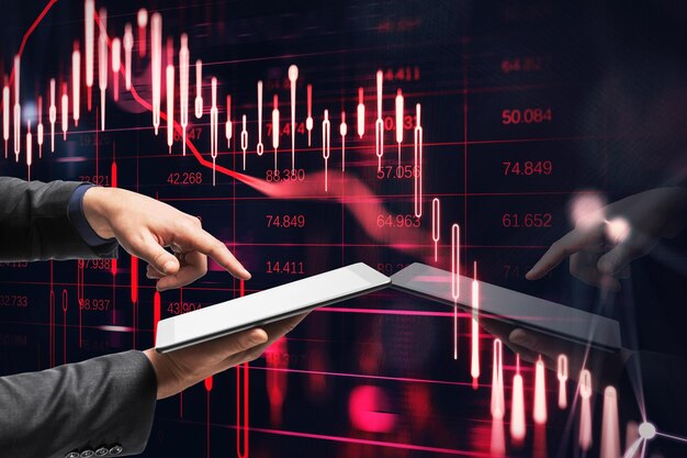 Close up of businessman hand pointing at cellphone with downward red candlestick chart on dark background Financial crisis and recession concept Double exposure