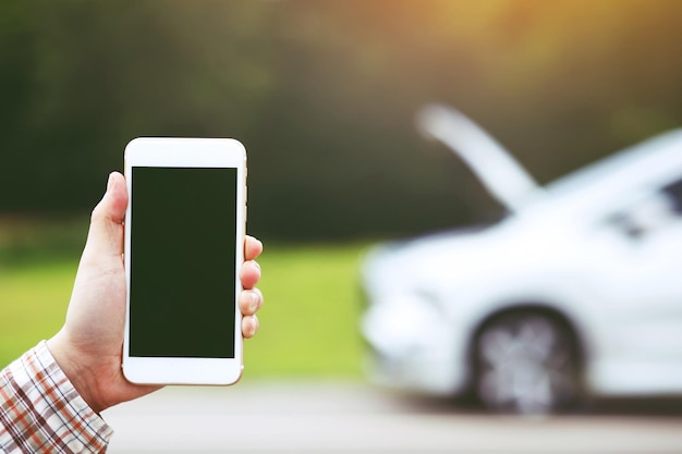 Close up businessman hand using a mobile smart phone call a car
mechanic ask for help assistance because car broken standing wait
beside the road blank of empty screen