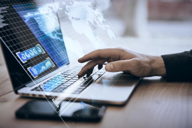 Close up of businessman hand using notebook keyboard on desk with smartphone and creative blue radar map interface on blurry background Spy and hud concept Double exposure