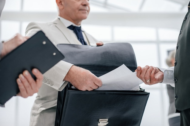 Close up. businessman handing documents to a Bank employee. business concept