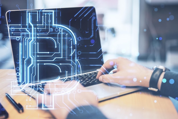 Close up of businessman hands using laptop with creative glowing bitcoin circuit hologram on blurry background Cryptocurrency blockchain and finance concept Double exposure