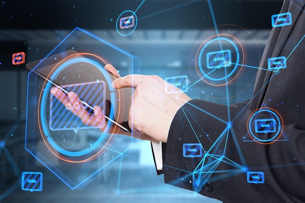 Close up of businessman hands using tablet with creative glowing connected communication hologram on blurry office interior background Technology and wireless networking concept Double exposure