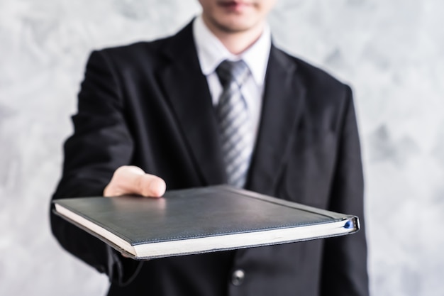 Close up of businessman holding documents on grunge background.