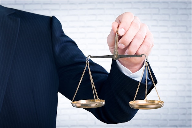 Close-up businessman holding Scales in hand