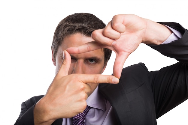 Close-up of a businessman looking through finger frame