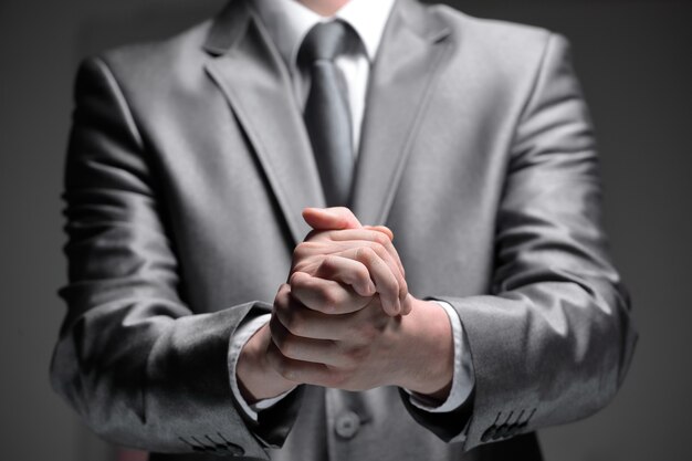 Close up.businessman shows a sign with his hands.isolated on black background.