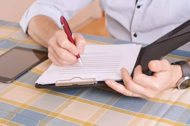 Close-up of businessman signing a document