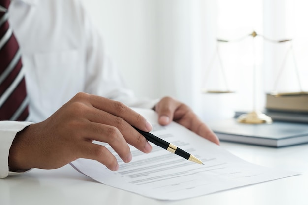 Close up businessman signing legle agreement document contract with partnership agreement after successful negotiation deal