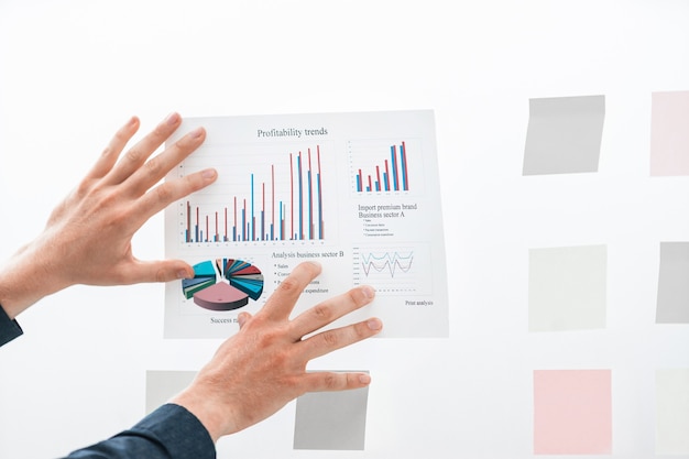 Close up businessman sticking to the glass financial chart board