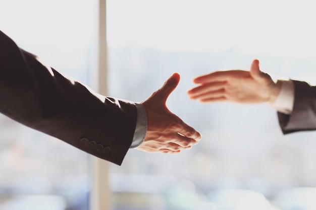 Close up businessman stretching out his hands to each other for a handshake