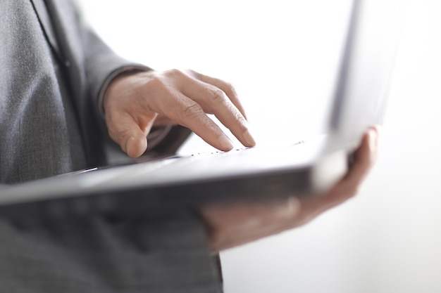 Close up.businessman typing on a laptop keyboard.isolated on white background