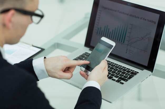 Close up businessman uses gadgets to check financial data