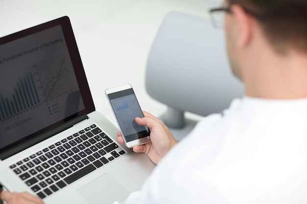 Close up businessman using gadgets to check financial data