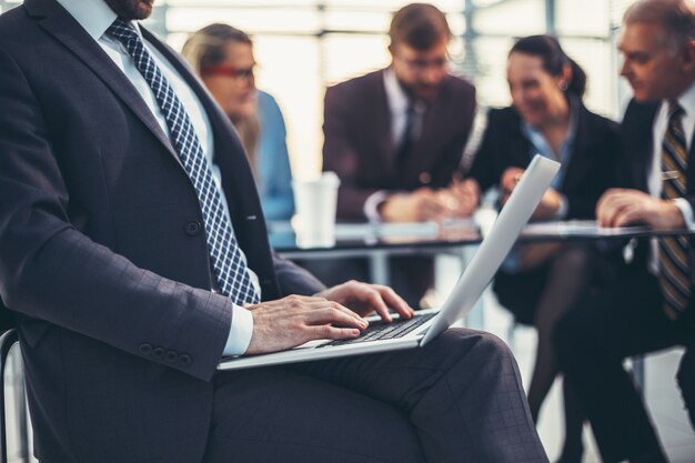 Photo close up. businessman using laptop in office. people and technology