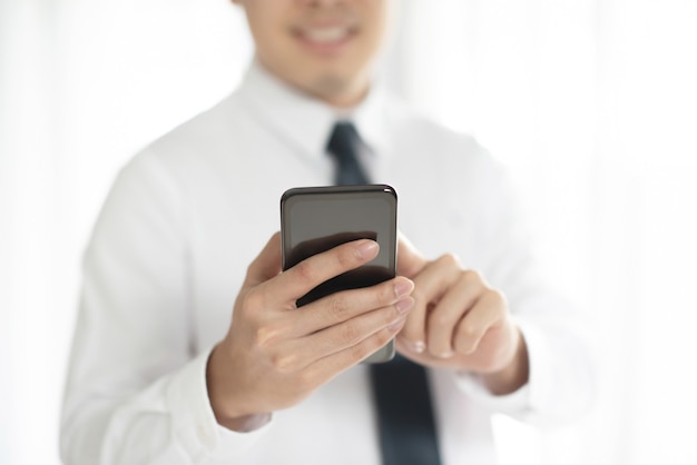 Close up of a businessman using mobile smart phone.