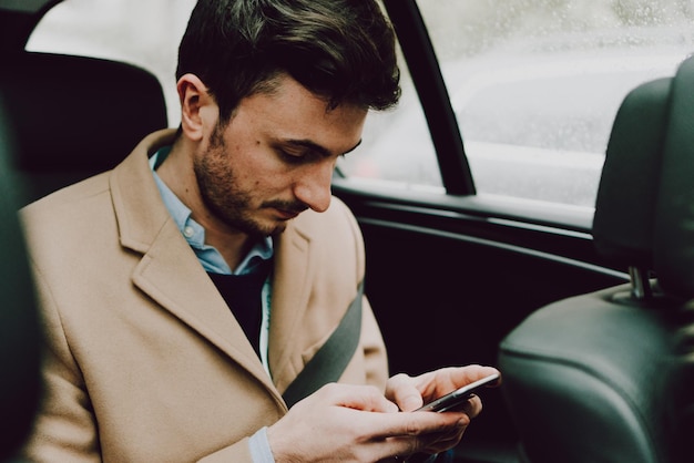 車で旅行している間電話を使っているビジネスマンのクローズアップ
