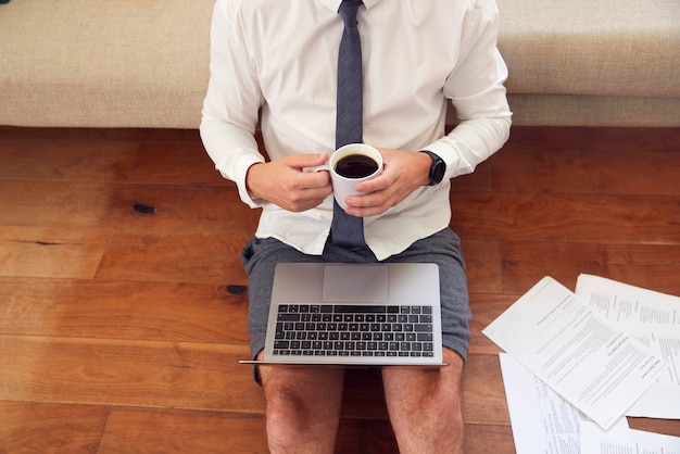 Крупный план бизнесмена в домашней одежде, рубашке и галстуке на ноутбуке, работающем из дома