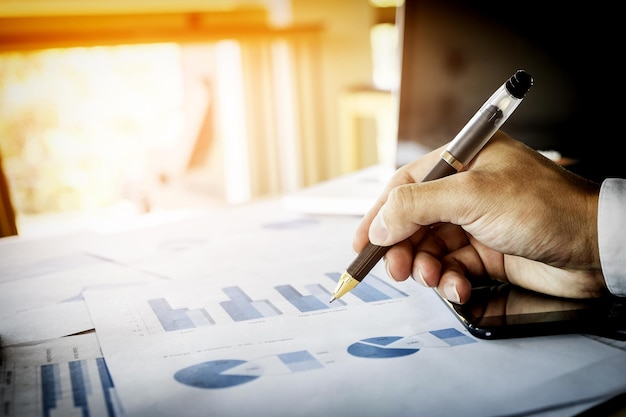 Close-up of businessman working on chart at table